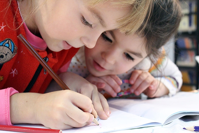 Educational outcomes for children (two girls coloring)
