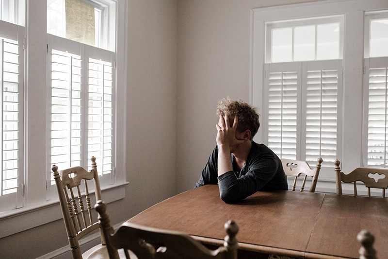Housing cost burden (man holding head looking stressed)