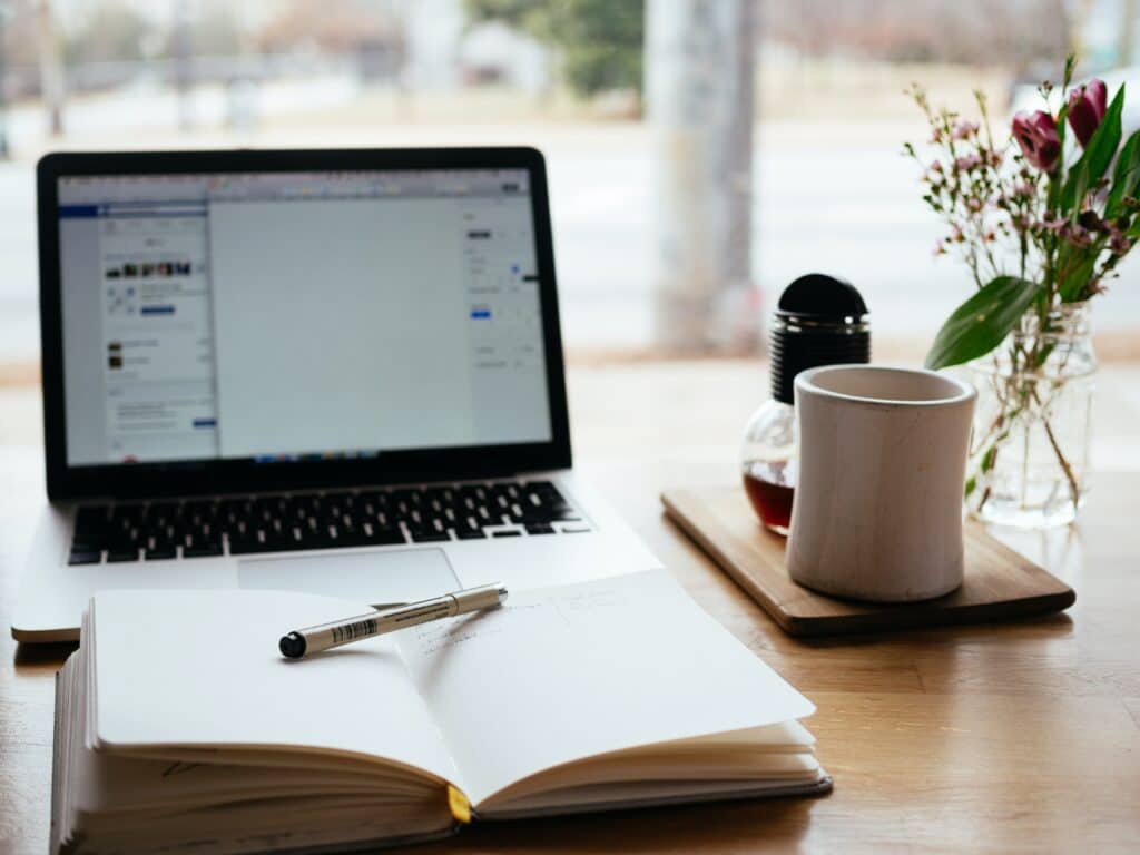 Image of computer and notebook shown