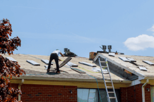 A person is seen repairing a roof. The image is used to illustrate home repair programs.