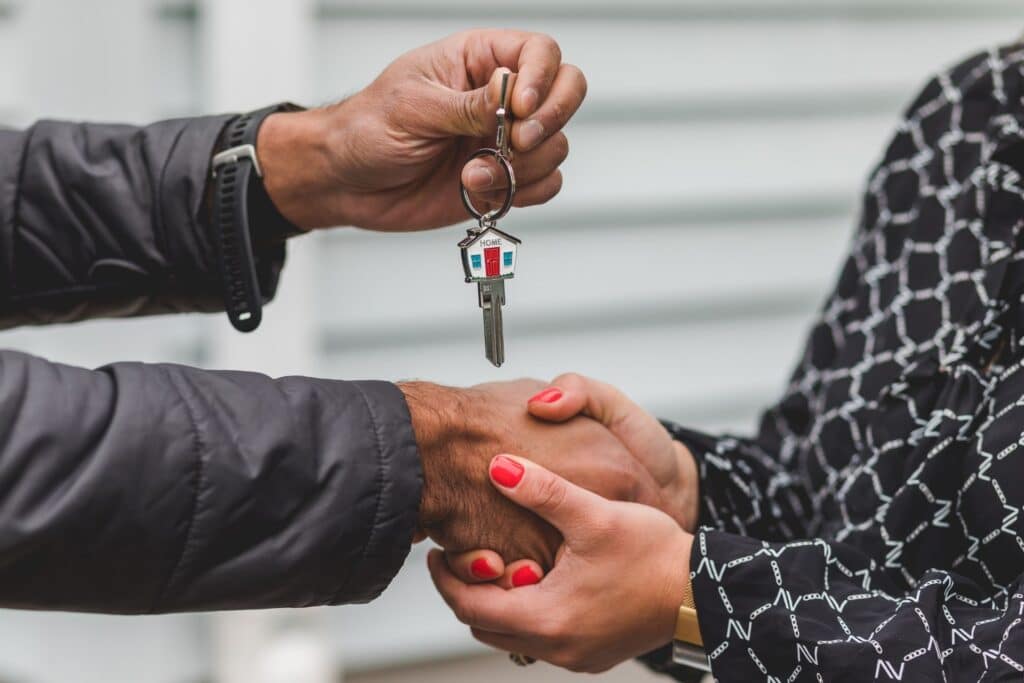 Image of a person being given a key to a home is shown