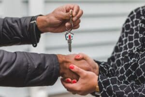 Image of a person being given a key to a home is shown